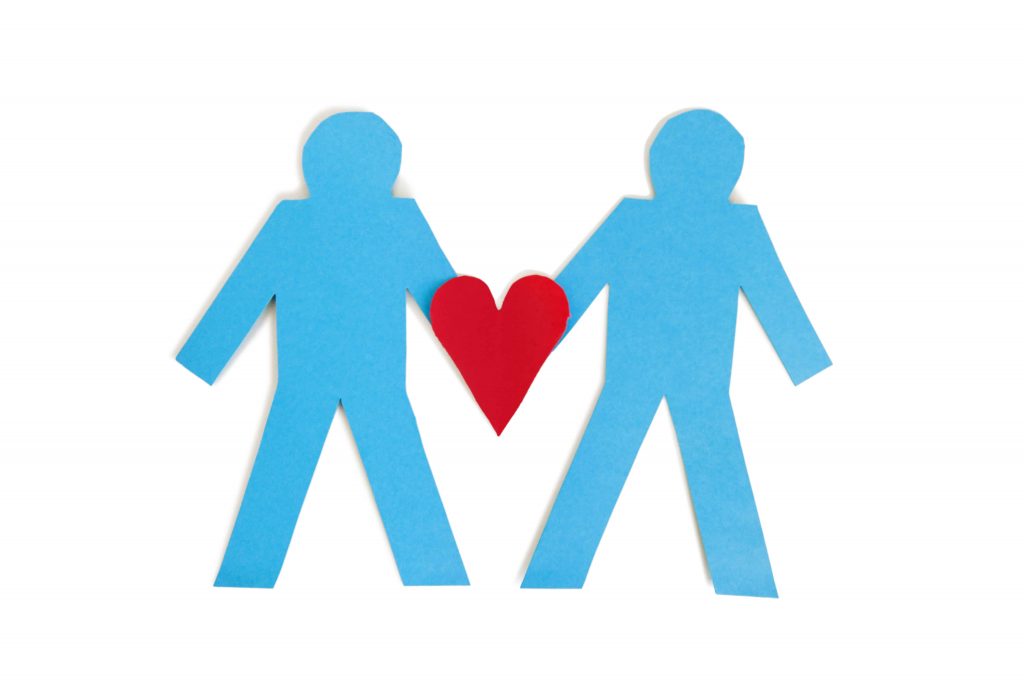 Two paper cut outs with a heart, indicating a successful business partnership.